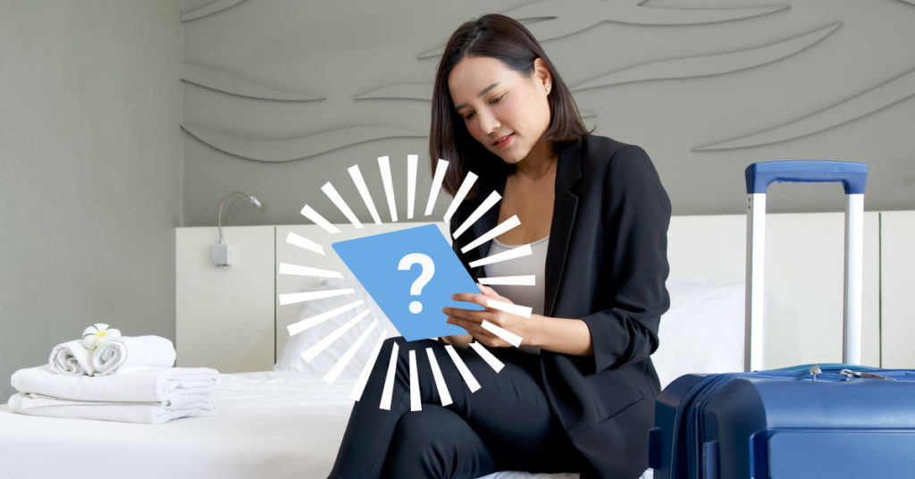 7 Reasons Guests Love Smart-Rooms - Woman in a hotel room holding a device which is hidden with a drawn on blue rectangle