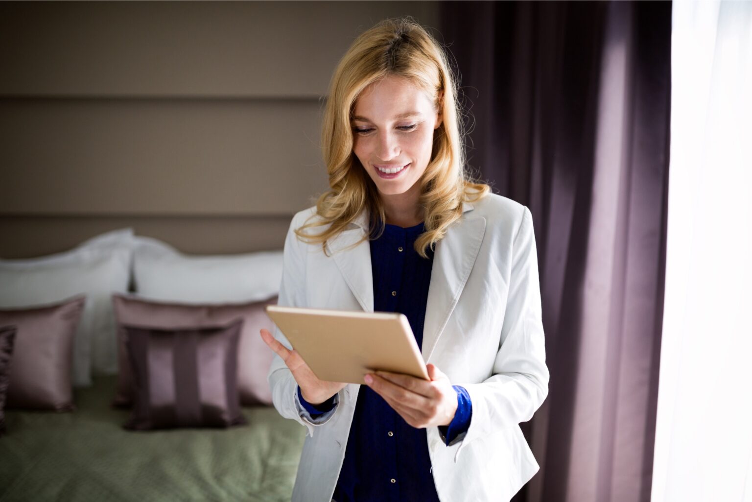 Woman standing in a hotel room using a tablet.jpg